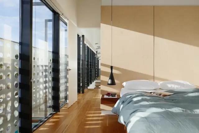 Chambre lumineuse avec parquet et grandes baies vitrées