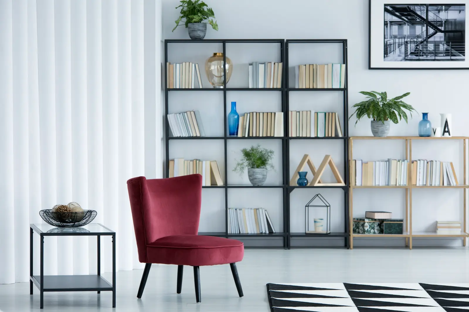Salon aménagé avec bibliothèque murale et fauteuil rouge